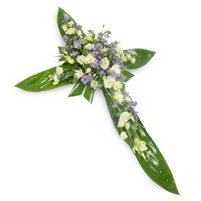 A carefully constructed floral cross photographed slightly from above on a crisp white field, the design anchored by broad, lustrous green leaves-Ti-like tropicals-arranged to form precise vertical and horizontal arms. These leaves present smooth, waxy planes and clear venation that catch the soft studio light, giving the base a living, protective quality. Concentrated at the cross's centre and running along its arms is a luxuriant spray of flowers in quiet tones: creamy ivory and pure white lisianthus with their layered, fluted petals; small, rounded white spray chrysanthemums or miniature roses that add gentle points of light; and clusters of tiny, star-shaped lavender flowers-limonium or asters-that introduce a soft violet breath across the composition. Fine green fillers and delicate foliage threads are woven through the blooms to add air and texture against the dense floral bands. The overall impression is one of serene craftsmanship-textural contrasts between the glossy leaves and feathery blooms, a muted, green-tinged scent, and an even wash of light that emphasizes calmness rather than drama. Designed to offer solace, this cross is a dignified choice for funerals, memorial services, and church tributes throughout the Eastcote and Ruislip area, where local families often choose simple, reverent floral expressions for moments of remembrance. The piece reads as both a statement of faith and a gentle emblem of enduring peace.
