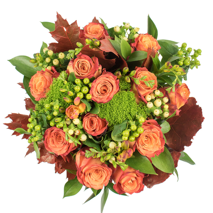 Seen from above on a crisp white surface, this autumn-inspired arrangement presents as a dense, circular composition that celebrates texture as much as colour. The focal point is a congregation of fully opened roses in warm peach and deep orange; their petals move from soft, candlelit peach at the centre to coral and then a deep, rust-tinged red at the outer edges, producing a natural ombré reminiscent of turning leaves. Interspersed among the roses are clusters of Hypericum berries, some a vivid lime-green that seems to vibrate against the floral tones, others a creamy pale yellow that softens and balances the palette. Plush pockets of green trick dianthus - small, round, and almost furry in appearance - contribute an herbal, moss-like texture that invites touch and contrasts beautifully with the smooth rose petals. Large lobed leaves in dark reddish-brown and burgundy are placed throughout to introduce an autumnal, woodsy note, while assorted glossy green foliage fills and lifts the bouquet, creating depth and a sense of abundance. Under soft natural light, the variety of surfaces - velvety petals, glossy berries, textured dianthus, and burnished leaves - catch highlights and shadow in a way that makes the composition read as both luxurious and comfortably familiar. Crafted with an eye toward seasonal charm, this bouquet would work wonderfully as a Thanksgiving centrepiece or a heartfelt gift, and is the type of arrangement Eastcote Flowers often prepares for same-day delivery around Eastcote, Pinner, and Ruislip when clients want a warm, local accent for their autumn table.